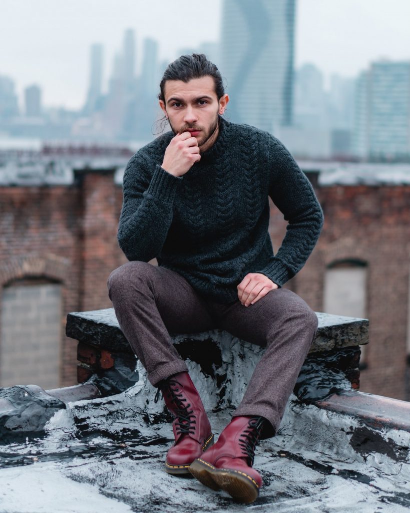 Photo by David Suarez man in black sweater and brown pants sitting on brown wooden bench